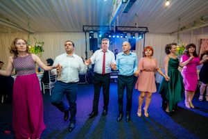 Party guests dancing in a festive indoor space with dramatic lighting and decor.