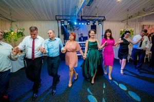 People enjoying group dance activities at an indoor celebration with mood lighting.