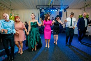 Dancers moving in formation at an indoor venue with blue and purple lighting effects.