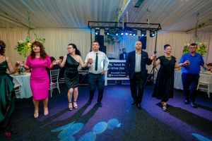 Group dancing together at a celebration with colorful lighting and decorative elements.