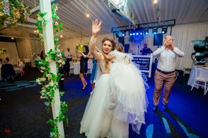 Wedding celebration with decorative green vines and blue lighting on the dance floor.