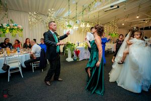 Wedding reception dancers enjoying themselves under hanging floral decorations.