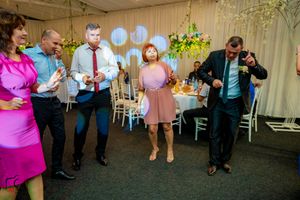 Wedding guests dancing and celebrating in a beautifully decorated reception venue.