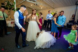 Wedding party members gather around for an entertaining dance moment at the reception.
