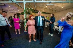 Indoor party venue with guests dancing under atmospheric lighting and decorations.
