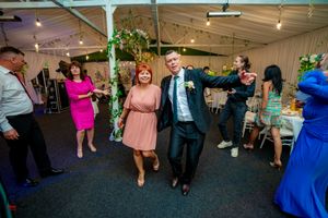 Event space filled with dancing guests under ambient lighting and ceiling decorations.