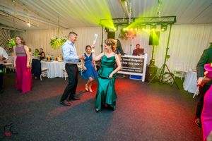Celebration in a decorated indoor venue with yellow and blue accent lighting.