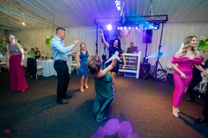 People dancing and socializing at a festive indoor party with colorful lighting effects.