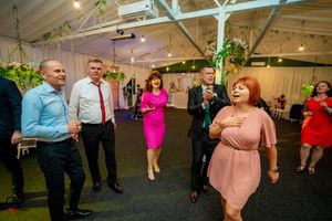 Guests dancing and mingling at an indoor event space with decorative lighting.
