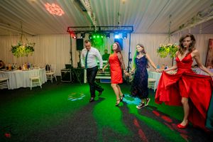 Wedding celebration featuring energetic group dancing with red and green lighting effects.