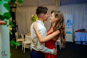 Dancers sharing intimate moments on the dance floor under green lighting effects.