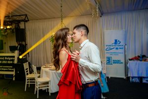 Dance partners moving gracefully across a decorated indoor venue with ambient lighting.