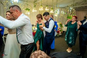 Wedding reception dance floor with guests dancing under elegant hanging floral decorations.