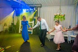 Wedding dance floor scene with blue lighting and guests enjoying the celebration.