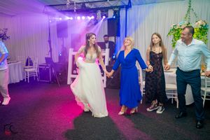 Wedding reception dance floor illuminated with purple and blue lighting effects.