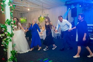 Wedding reception dance floor with blue lighting and white tent draping.