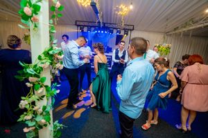 Reception hall with blue and green lighting effects creating a festive party atmosphere.