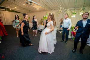 Wedding reception dance floor with guests dancing under decorative hanging lights.