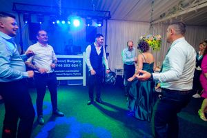 Wedding reception dance floor with blue lighting and guests gathered in a circle.