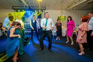 Indoor party venue with blue and multicolored lighting creating a festive dance atmosphere.