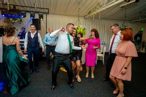 Indoor celebration with guests dancing under atmospheric lighting and decorative ceiling elements.