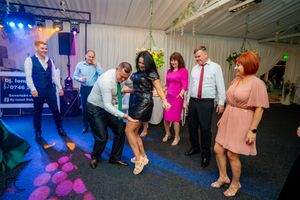 Party venue with dynamic lighting effects and guests enjoying themselves on the dance floor.