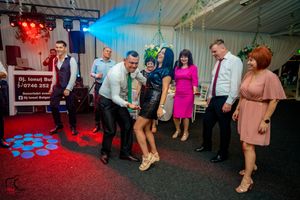 Event space illuminated with blue and red lighting while guests mingle and dance.