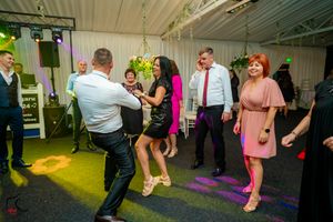 Wedding reception dance floor with dynamic lighting and guests in motion.