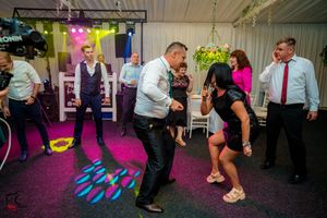 Wedding reception dance floor with vibrant pink and purple lighting effects.