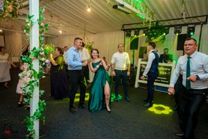Wedding reception venue decorated with green uplighting and floral arrangements.
