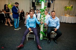 A wedding reception venue decorated with green lighting and floral arrangements.