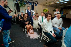 Wedding celebration in a venue with industrial ceiling and green-lit decorative elements.