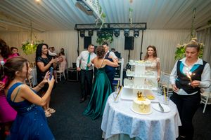 Wedding reception hall decorated with hanging lights and floral arrangements.