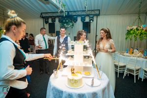 Indoor wedding reception space with blue lighting and white tablecloths.