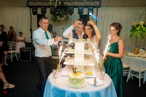 Wedding celebration in progress with colorful lighting and elegant table decorations.