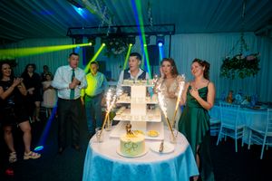 Wedding reception hall featuring theatrical lighting and elegantly arranged celebration tables.