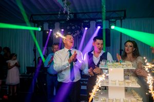 Wedding reception hall with colorful lighting effects and decorated tables for an evening celebration.