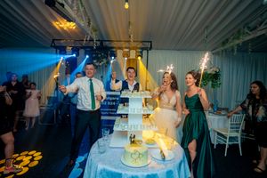 Wedding celebration with yellow lighting effects and sparklers surrounding elegant tiered display.