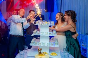Wedding reception cake ceremony with dramatic blue and red lighting effects.