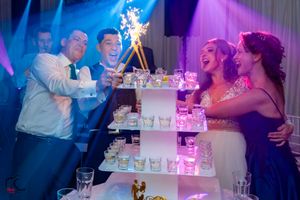 Wedding cake cutting ceremony with blue and purple lighting creating a dramatic atmosphere.