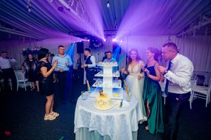 Event space bathed in purple lighting with elegant table arrangements.
