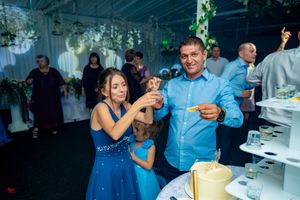 Celebration at an indoor venue with guests in blue attire enjoying refreshments.