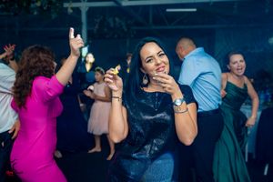 Wedding reception party with guests dancing under blue mood lighting.
