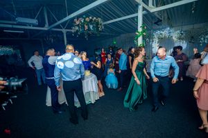Wide shot of wedding reception dance floor with guests celebrating in a large venue.
