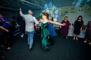 Lively dance moves on display at a wedding reception under decorative lighting.