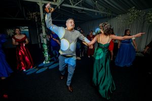 Energetic dancing at a wedding reception with guests in colorful formal attire.