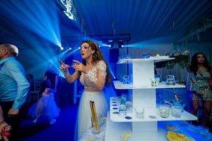 Reception venue illuminated with dramatic blue lighting and a tiered display setup.