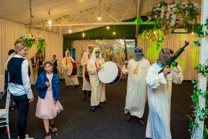 Celebration in a decorated tent venue with string lights and floral arrangements overhead.