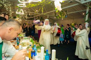 Traditional performers entertain wedding guests during a festive indoor celebration.