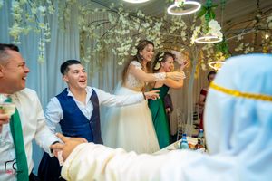 Wedding venue decorated with circular lighting fixtures and hanging floral arrangements during celebration.